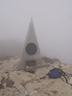 Summit marker in the fog.